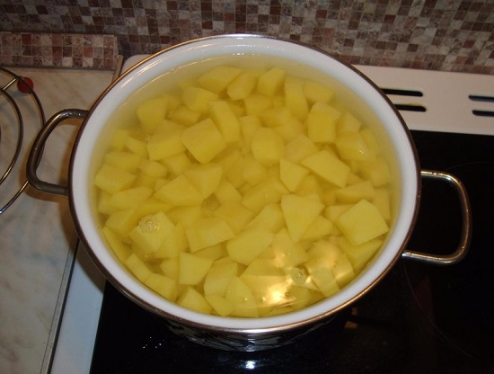 Выкладываем измельченный картофель в кастрюлю