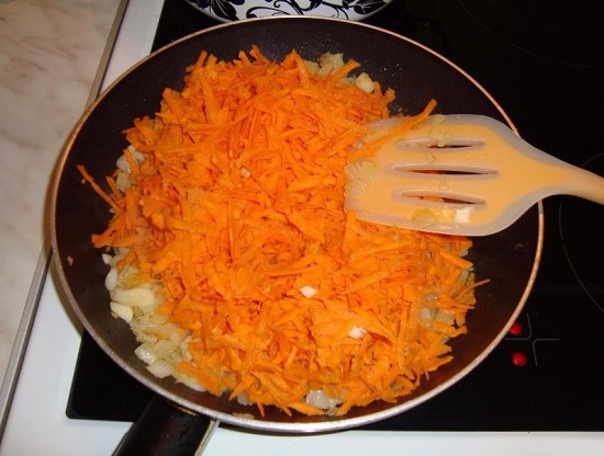 Затем выкладываем в сковороду натертую морковь