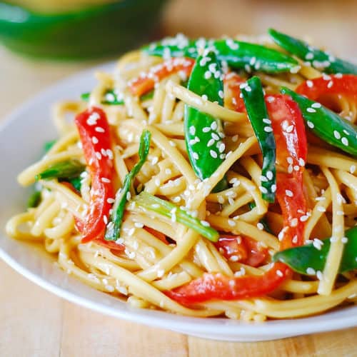 Cold Asian noodle salad recipe with snap peas, red bell peppers, and toasted sesame seeds