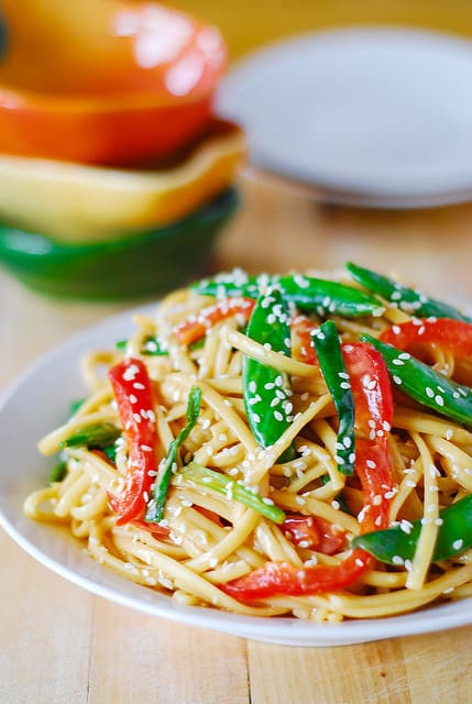 Cold Asian noodle salad recipe with snap peas and red bell peppers topped with toasted sesame seeds