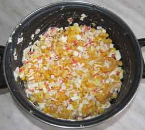 Готовый салат с крабовыми палочками и апельсинами в кастрюле