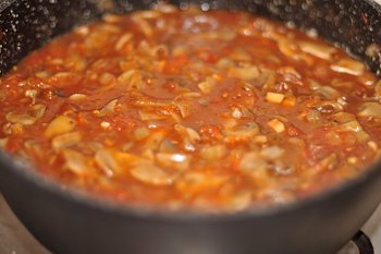 К грибам добавляется томатный соус и вода