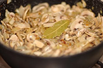 Грибы жарятся на оливковом масле с луком чесноком лавровым листом