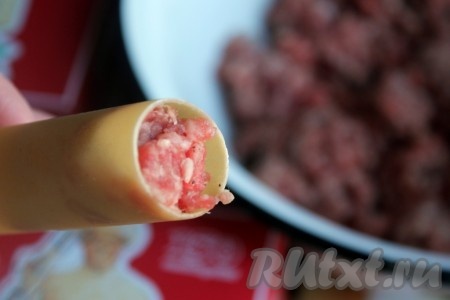 Наполнить половину упаковки каннеллони сырым мясным фаршем с молотыми перцами, а вторую половину трубочек - грибной начинкой.