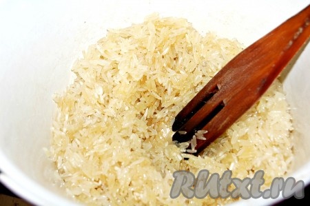 Когда масло с карри начнет кипеть, добавить сухой рис. Размешать деревянной ложкой. Обжаривать 5 минут.