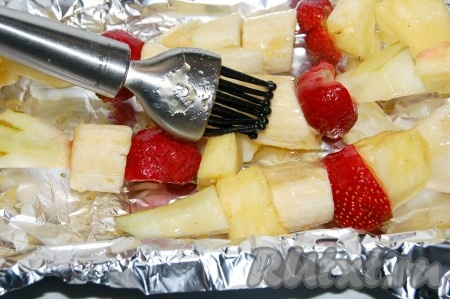 Взять огнеупорную форму (можно сковороду), выстелить ее фольгой, на фольгу выложить фруктовые шашлыки и обильно смазать их полученным соусом.