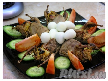 Перепелок, фаршированных рисом, сухофруктами и апельсинами, украсить яйцами и овощами. 