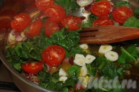 Затем к луку добавляем зелень, нарезанный чеснок и помидоры. Обжариваем в течение нескольких минут.