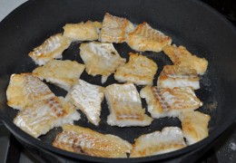 Пока соус тушится, раскалить во второй сковороде масло. Обвалять рыбное филе в муке и быстро обжарить треску до образования румяной корочки (одну сторону – 1-1,5 минуты).