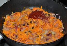 Положить пару ложек томатной пасты, посыпать сахаром, солью, бросить перец-горошек. Помешивая, обжаривать 1,5-2 минуты.