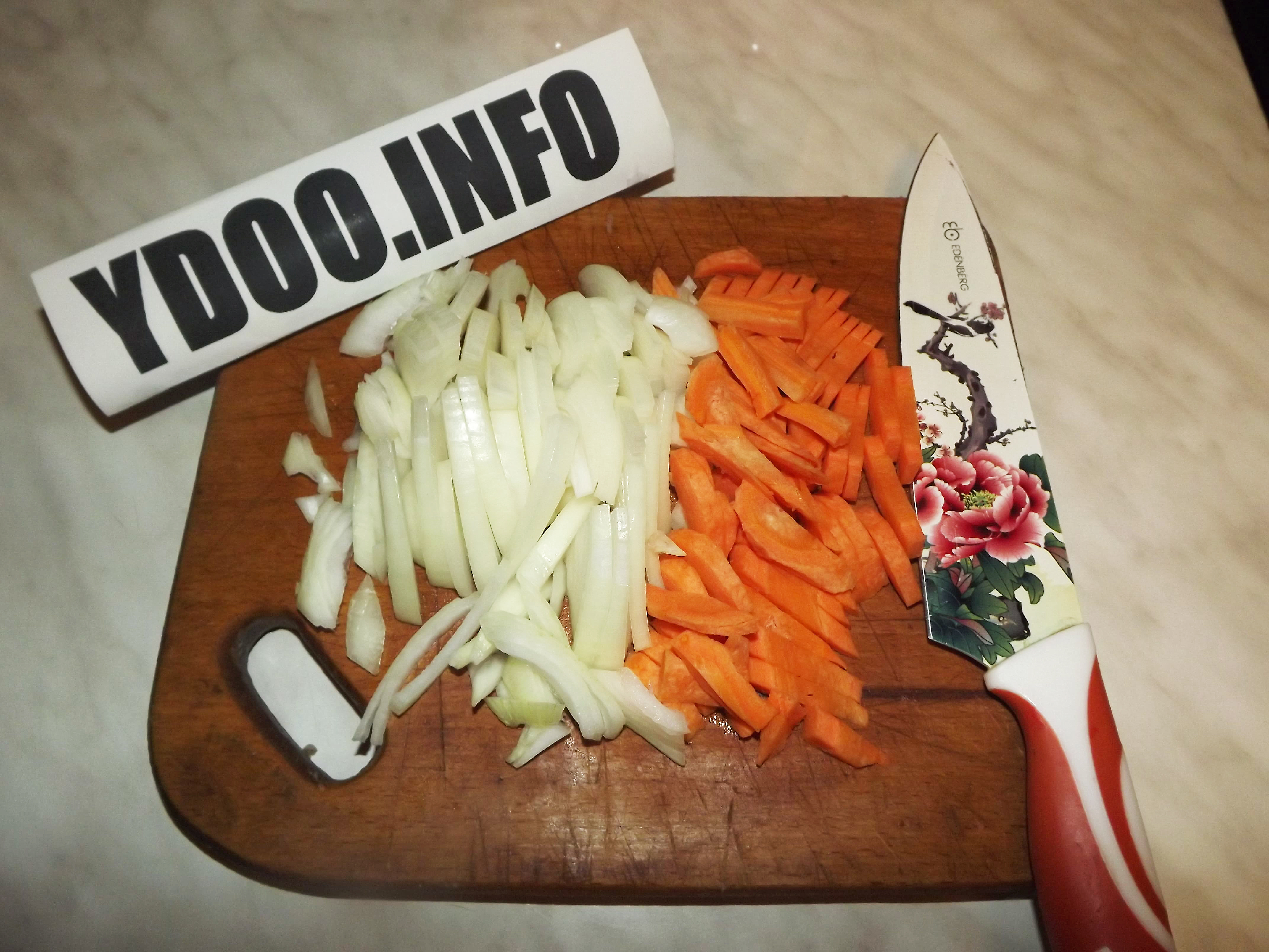 нарезанные морковь и лук на деревянной разделочной доске