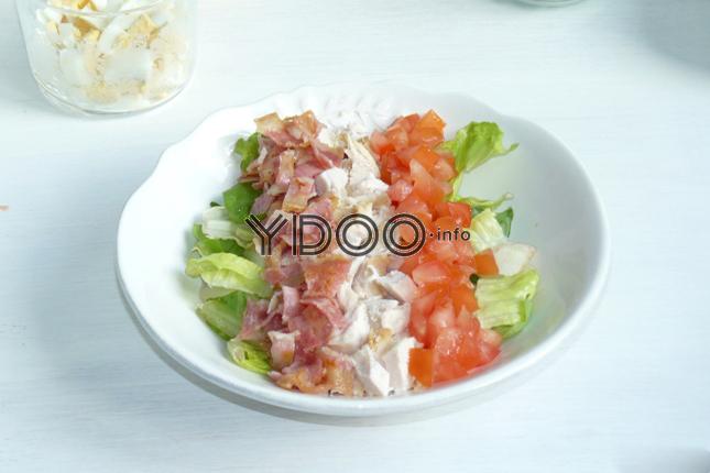 салат из мяса и овощей, выложенный в тарелке продольными слоями
