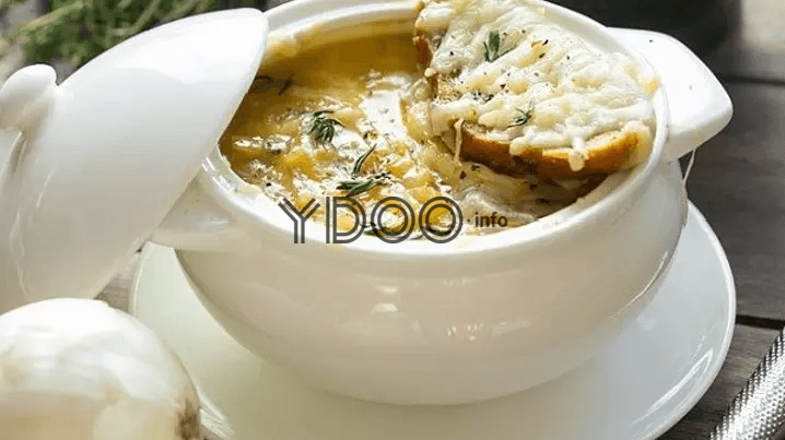 луковый суп в супнице с сыром и гренкой
