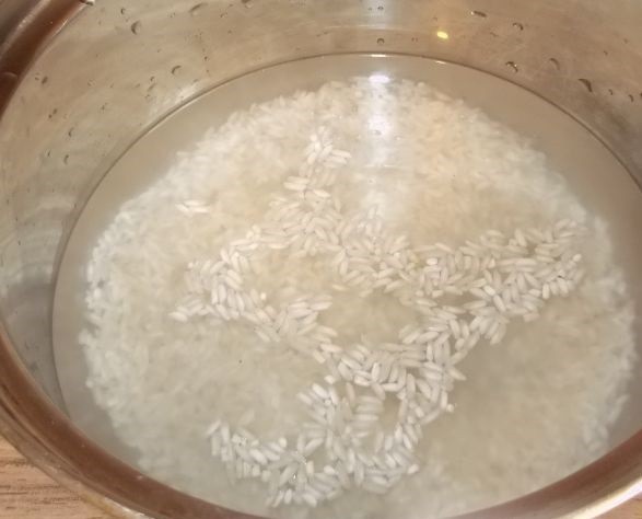 рис, залитый водой, в миске