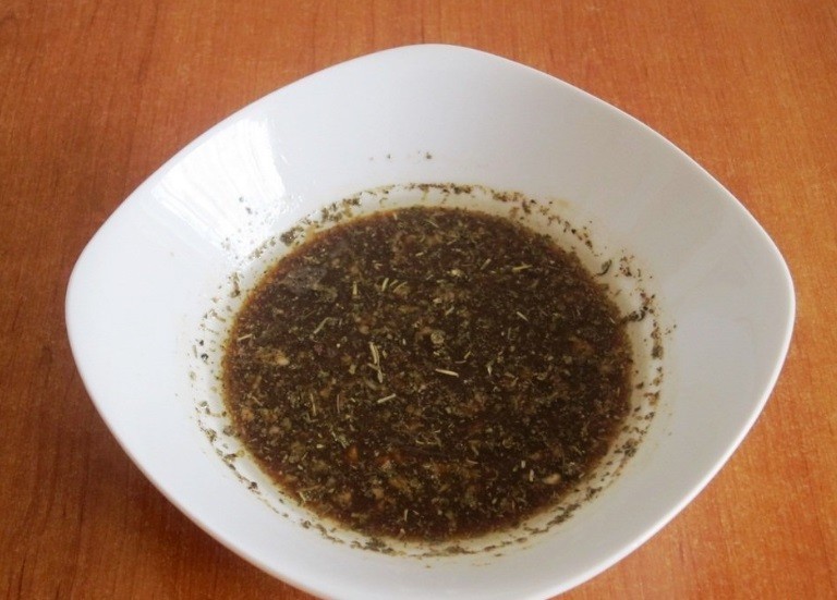 маринад из соевого соуса и специй в глубокой белой тарелке на столе
