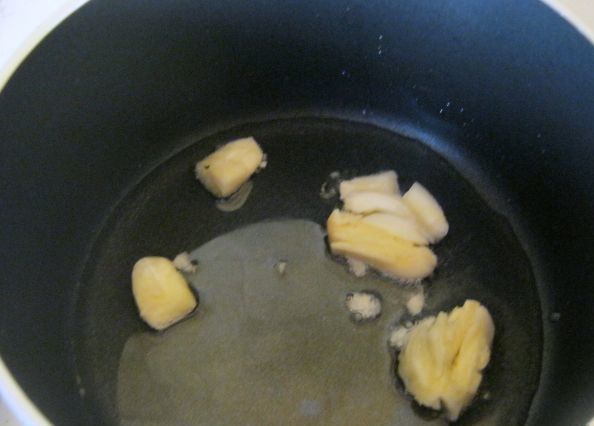 раздавленный чеснок в сковороде с маслом