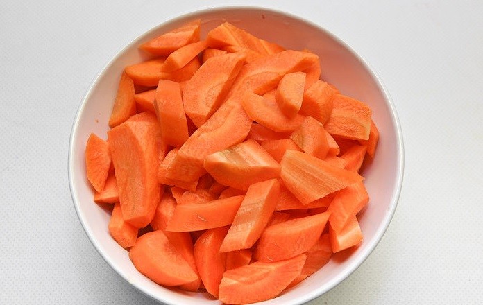 нарезанная брусочками морковь в белой миске на столе
