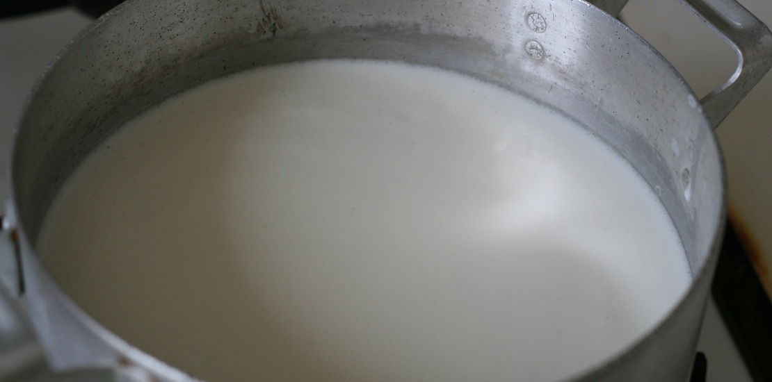 молоко в большой алюминиевой кастрюле